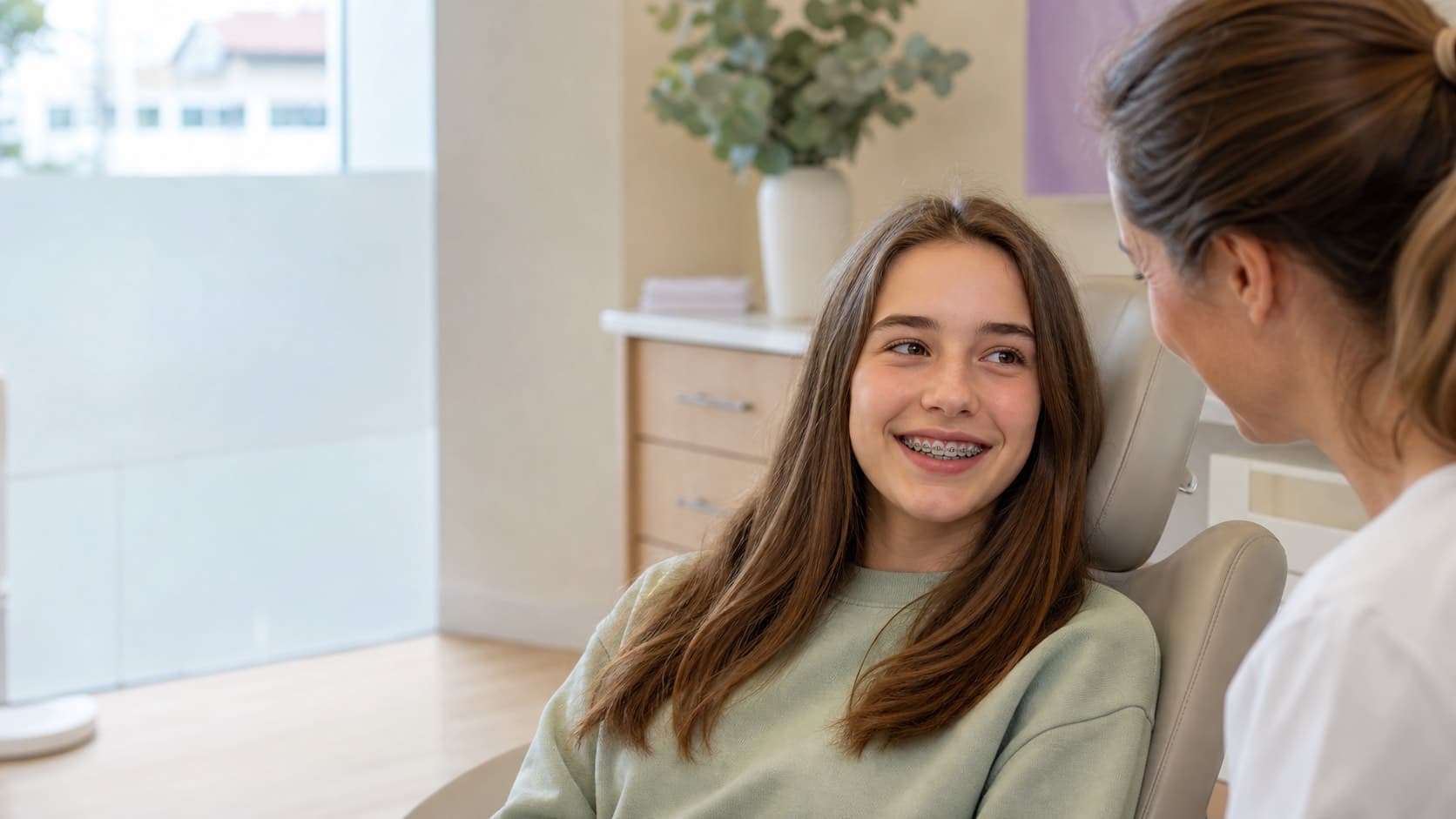 Adolescent souriant portant un appareil dentaire lors d’un contrôle