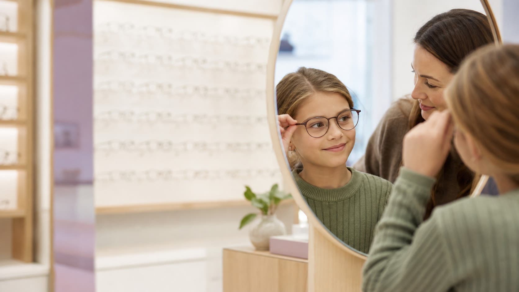 Enfant essayant une monture de lunettes chez l’opticien