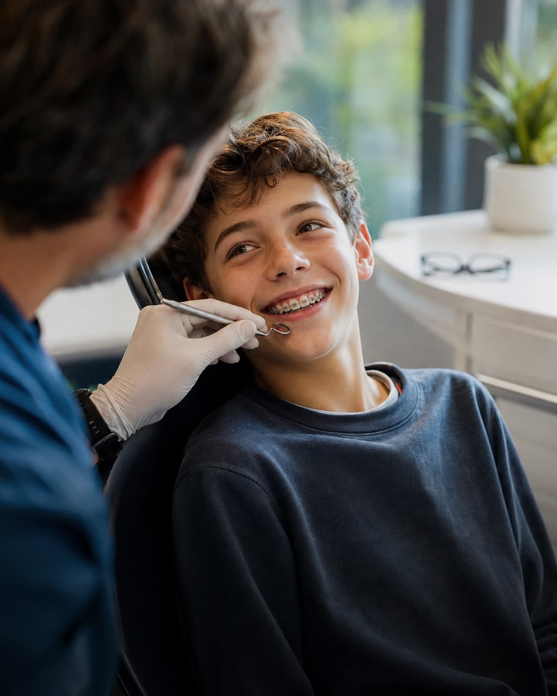 Jeune adolescent souriant pendant le contrôle de son appareil dentaire