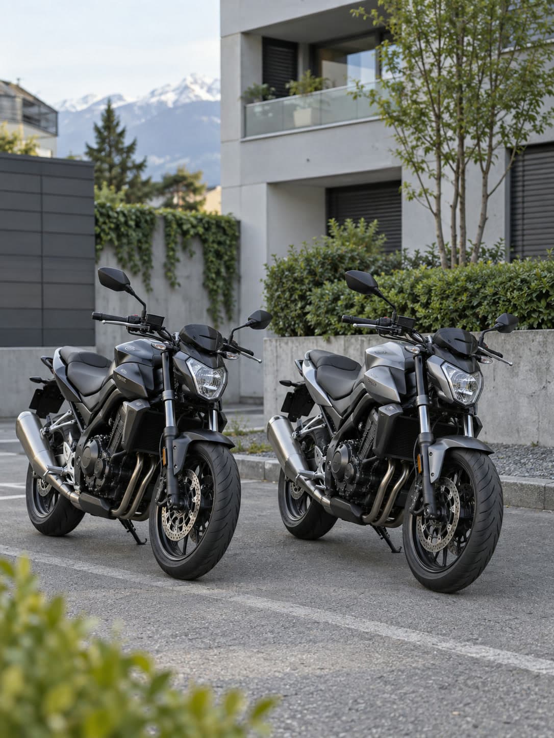 Deux motos grises similaires garées côte à côte dans une cour résidentielle