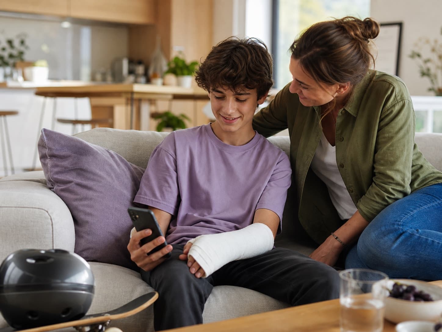 Adolescent avec le bras plâtré accompagné par sa mère à la maison
